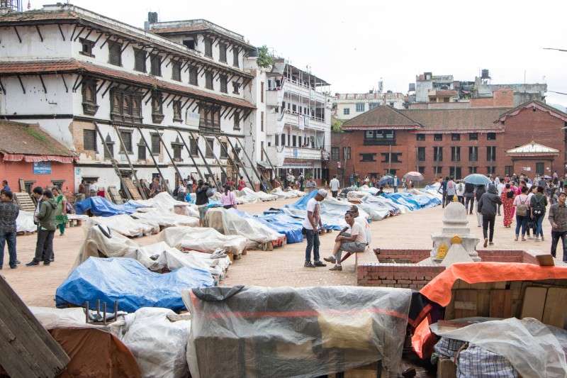 Vendors covering their curio items with plastic sheets at Basantapur to protect them from the rain. Photo: Pradip Luitel/NBA