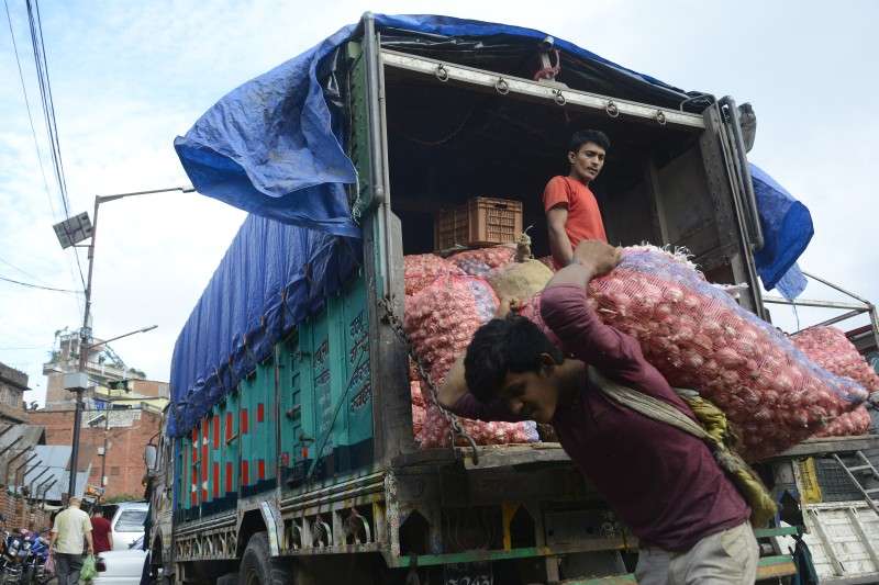 Labourers unloading garlic imported from Surkhet at Kalimati Vegetable Market on Monday. Garlic is available at Rs 90 per kg in bulk at the vegetable market. Photo: Ravi Maharjan/NBA