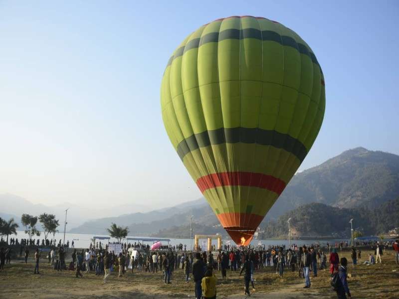 People gathered at Halanchowk of Pokhara on the New Year’s eve to watch the hot-air balloon, which has been operating since a month. Domestic tourists can travel in the hot-air balloon for a price of Rs 9,500 while foreigners are charged US$ 150. Photo: Ravi Maharjan/NBA